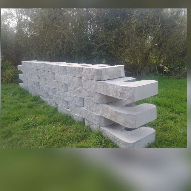 A real Aquacast W-block retaining wall built outdoors in a field